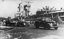 KNIL units passing light cruiser De Ruyter in Soerabaja, c. 1940 Hr. Ms. De Ruyter moored in Soerabaja.jpg