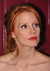 A shot of a red-haired woman as she looks away from the camera