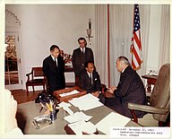 LBJ встречается с тремя другими за столом. Верх зеленый.