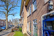 Naoorlogse panden aan de Merwedestraat met een gevelfiguur van een fotograaf van Anno Smith.