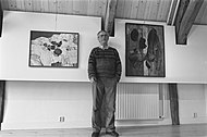 Jopie Huisman staat tussen twee van zijn schilderijen in het Jopie Huisman museum, april 1986
