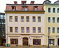 Wohnhaus in geschlossener Bebauung, mit zwei Hofflügeln und Einfriedungsmauer im Grundstück und am Theatergäßchen