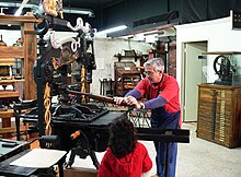 A member of staff at the International Printing Museum demonstrates printing with a 19th-century, hand-operated Columbian press. PrintMus 081.jpg