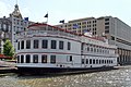 The rear of the hotel spanning River Street, with the Savannah River Queen in the foreground