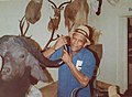 man standing with taxidermied mammal