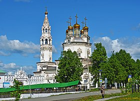 Vue d'un bâtiment religieux de couleur blanche surmonté de quatre dômes portant des croix