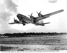 Black and white photo of a four engined aircraft taking off
