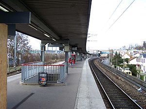 Le quai central de la gare de Conflans-Fin-d'Oise, vu en direction de Cergy. On distingue au fond le viaduc de la ligne de Paris à Mantes par Conflans, qui offre une correspondance.