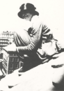 Amelia Earhart, wearing a black brimmed hat, sitting on the roof of a domed building at Columbia University in 1920.