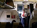 Replacing a low resolution photo with an "original research" caption (she could be conferring with fellow flight attendants at the rear of the cabin), with