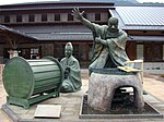 Sculptures of a drummer and a person on a water outlet.