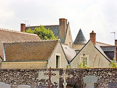 Photographie en couleurs de deux toits, dont celui d'une tour ronde, émergeant d'autres toits environnants.