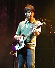 Guitarist Gem Archer performing at an Oasis concert.