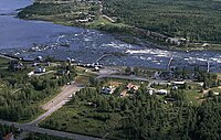 Kukkolaforsen med den svenska sidan närmast fotografen. Kulturbyggnaderna med kvarnarna finns till vänster, och i vattnet syns patorna. Till höger finns restaurangbyggnaden. Fotat augusti 1994.