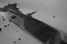 Photograph of a knife and splattered blood with a fingerprint visible on the blade.