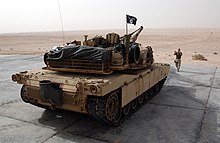 A Marine M1A1 fitted with snorkel attachment and bustle rack extension US Navy 031214-N-3236B-008 A Marine from the 13th Marine Expeditionary Unit (13th MEU) Tank Platoon BLT 1-1 stationed at Twentynine Palms, Calif., directs an M1-A1 Abrams tank during a training exercise.jpg