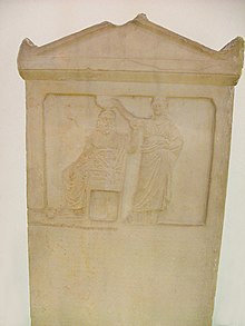 The relief representation depicts the personified Demos being crowned by Democracy. About 276 BC. Ancient Agora Museum. Demos embodiment being crowned by Democracy. Ancient Agora Museum in Athens.jpg