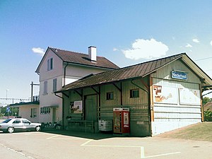 Three-story building with gabled roof and adjoining freight house
