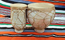 2 poteries fermées par des peaux, liées et cerclées par des lanières de cuir, posées sur une couverture marocaine.