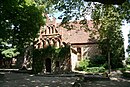 Dorfkirche mit gusseisernen Grabkreuzen auf dem Kirchhof und Pfarrhaus