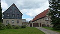 Bauernhof (Dreiseithof) mit Wohnstallhaus (Fachwerk) und Scheune sowie Auszüglerhaus (Fachwerk, teilweise verputzt), dazu Reste der alten Pflasterung im Hof