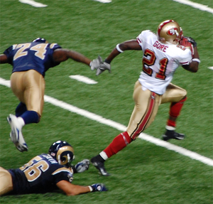 English: Frank Gore breaking through tackles a...