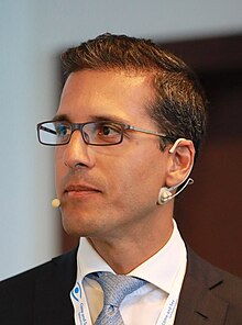 Prof. Kaweh Mansouri wearing a headset giving a presentation at the Oertli "Come and See" Meeting, 2018"