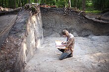 Archeologist writing in a journal while doing field work