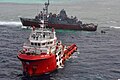 Vlečný člun se marně snaží vyprostit americkou minolovku USS Guardian (MCM-5) uvízlou na korálovém útesu