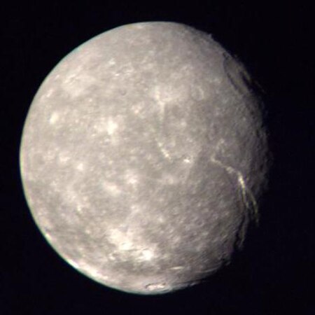 Fotografia de Titània (Urà iii) realitzada per la sonda espacial Voyager 2 a 500.000 km de distància, 1986. Es pot observar que la seva superfície té moltes cicatrius per impactes. Titània mostra proves d'alguna activitat geològica en algun moment de la seva història.