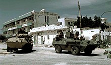 An American Cadillac Gage Light Armored Reconnaissance Vehicle and Italian Fiat-OTO Melara Type 6614 Armored Personnel Carrier guard an intersection during the Somali Civil War (1993). US Marine Cadillac Gage LAV and a Fiat-OTO Melara 6614 APC.JPEG