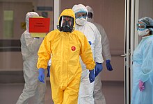 Putin (dressed in the yellow hazmat suit) visits coronavirus patients at the City Clinical Hospital No. 40 in Moscow, 24 March 2020. Vladimir Putin in Kommunarka hospital1.jpg