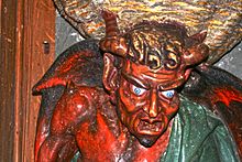 Sculpture représentant le Diable avec des cornes sur la tête.