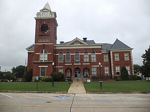 Butts County Courthouse (2013). Das Courthouse wurde 1898 fertiggestellt und weist Stilelemente  Viktorianischer Architektur auf. Im September 1980 wurde das Butts County Courthouse in das NRHP eingetragen.