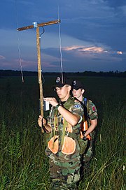 Civil Air Patrol members practice searching for an emergency locator transmitter.  The member in front is using a manual radio direction finder.