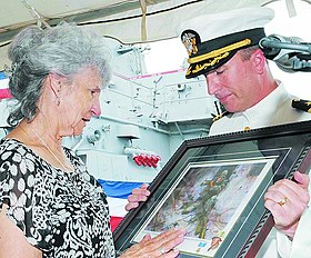2009 год. Долия Гонсалес принимает картину, на которой нарисован её сын, от коммандера Брайана Форта в ходе командной церемонии на борту эсминца USS Gonzalez