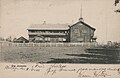 Herredshuset på brevkort fra rundt 1907. Tømmerbygningen ble opprinnelig reist 1901. Foto: Nasjonalbibliotekets bildesamling