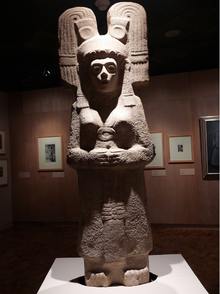 A stone sculpture of a woman wearing a headdress.
