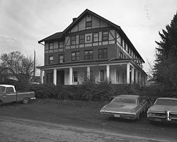 Photograph of the Kootenai Inn, a four-story structure with a broad veranda and half-timbered walls on the upper stories