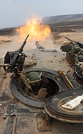 An M1A1 firing its main gun as seen from the loader's hatch in joint exercises with the French Foreign Legion in Djibouti in 2010. The M240 is visible left while the M2 is visible right. M1 Abrams turret fire above.jpg