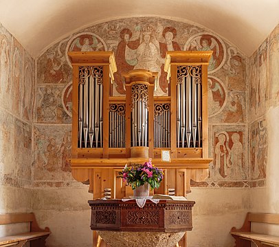 Órgão na igreja reformada de Waltensburg, cantão dos Grisões, Suíça. A igreja foi construída no final do século XI. É mais conhecida pelas pinturas de parede do mestre de Waltensburg. Suas pinturas estão entre as melhores obras da pintura gótica na Suíça. A igreja-salão retangular e capela-mor quadrada é dedicada aos Santos Desidério e Leodegário. Por volta de 1330 foi ampliada para oeste e ligada à torre fortificada, convertida em torre sineira. (definição 3 826 × 3 390)