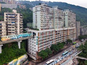 A train of Chongqing Rail Transit Line 2 coming through a residential building at Liziba