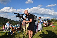 Ethnographer filming celebrations of the Assumption of Mary, Beskids, Poland Ethnographer filming celebrations accompanying the Assumption of the Holy Mary, Juszczyna, Poland.jpg