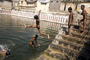 Boys skinny dipping in a sacred tank of water in India