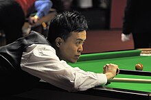 Marco Fu playing a shot with the rest