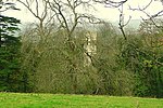 a stone tower, mostly hidden by trees