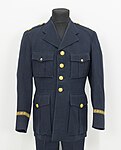 Uniformsjacka med byxor av modell 1954, med axelklaffar samt gradbeteckning för en polisinspektör.