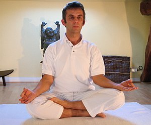 A man demonstrating the yoga posture siddhasan...