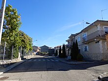 calle amplia con edificaciones a la derecha y parque a la izquierda