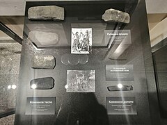 Pierres exposées dans un musée avec des indications russes, montrant au travers de 7 pierres les différents stades entre une pierre brute et une pierre polie.